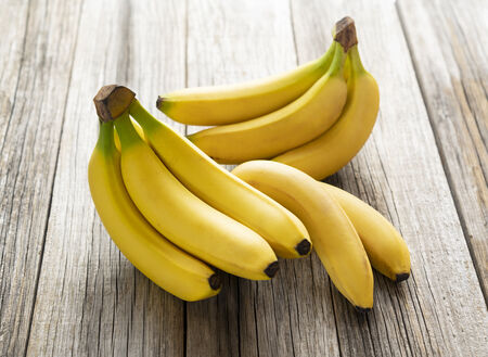 Sisir pisang Cavendish segar di atas papan kayu